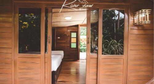 a room with wooden doors with a bed in it at River View Resort At Chaewlan in Ban Pha Saeng Lang
