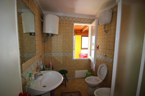 トッレ・デイ・コルサリにあるLe dune di Torre dei Corsariのバスルーム(洗面台、トイレ付)、窓が備わります。