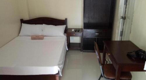 a bedroom with a bed and a desk and a bed sidx sidx sidx at Dino Residences in Dumaguete