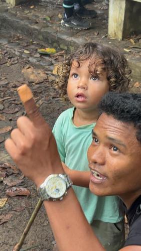a man holding a young child on his shoulders at Sumatra Expedition Lodge in Bukit Lawang