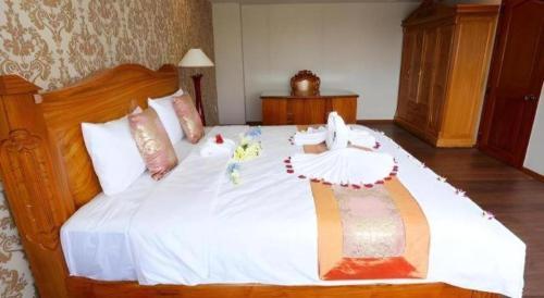 a bedroom with a large white bed with decorations on it at New Palace Bac Lieu Hotel in Bạc Liêu