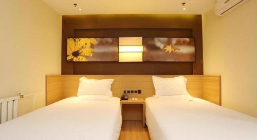 Ένα ή περισσότερα κρεβάτια σε δωμάτιο στο IU Hotel Tianjin Xiqing Zhong Bei Zhen Branch