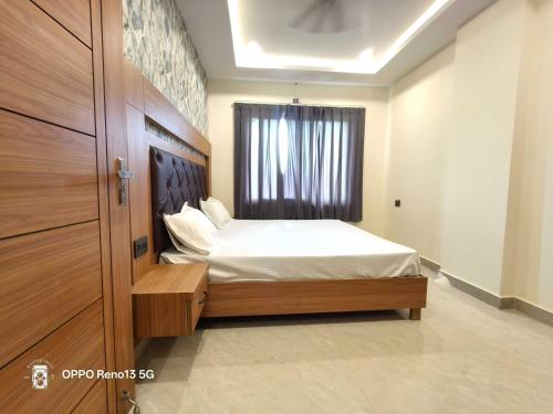a small bedroom with a bed and a window at Hotel O AVR STAY INN in Bhauli