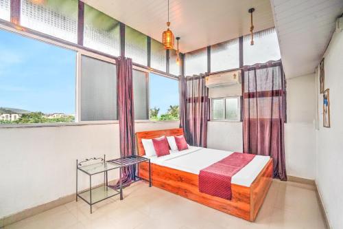 a bedroom with a bed in a room with windows at Villa Bliss by Palette Homes Lonavala in Lonavala