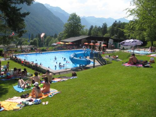 eine Gruppe von Menschen, die im Gras an einem Pool liegen in der Unterkunft Walch's Camping & Landhaus in Braz