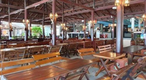 un ristorante vuoto con tavoli e sedie di legno di Saikaew Boutique Hotel a Ko Samed
