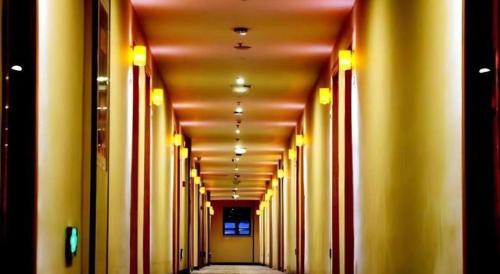 an empty hallway with yellow walls and yellow columns at 7 Days Premium Nanjing Gaochun Beiling Road Branch in Gaochun