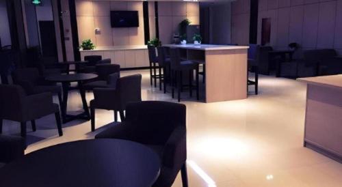 a restaurant with tables and chairs and a bar at 7 Days Premium Nanjing Gaochun Beiling Road Branch in Gaochun