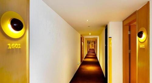 a hallway with a long hallway with eyes on the wall at 7 Days Premium Nanjing Gaochun Beiling Road Branch in Gaochun