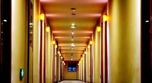an empty hallway with yellow walls and yellow columns at 7 Days Premium Nanjing Gaochun Beiling Road Branch in Gaochun
