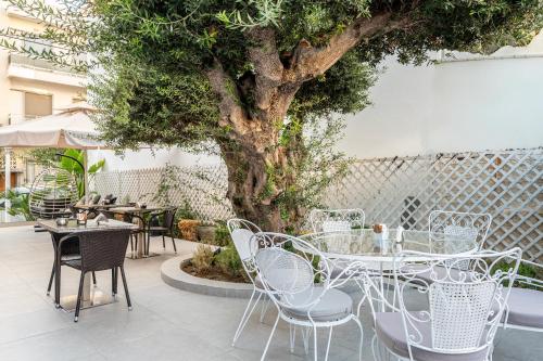 a table and chairs in front of a tree at Sonia Hotel & Suites in Kos Town