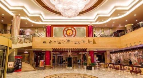 a large lobby with a chandelier in a building at New Friendship Hotel in Luoyang