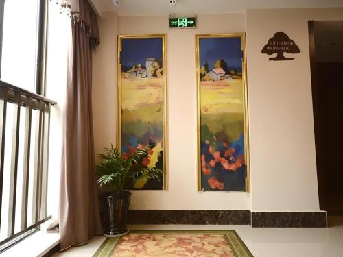 a room with three paintings on the wall at GreenTree Inn Anhui Xuancheng Ningguo NinGYAng East Road Darunfa Branch in Xuanzhou