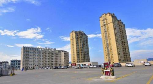 two tall buildings in a parking lot with a parking meter at GreenTree Inn Anhui Xuancheng Ningguo NinGYAng East Road Darunfa Branch in Xuanzhou
