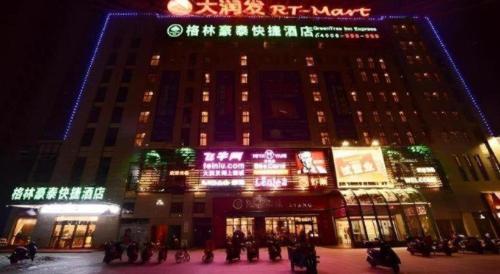 a large building with christmas lights on it at night at GreenTree Inn Anhui Xuancheng Ningguo NinGYAng East Road Darunfa Branch in Xuanzhou