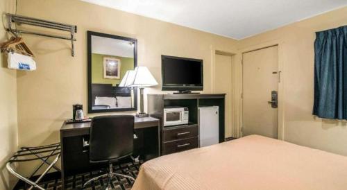 a hotel room with a bed and a desk with a computer at Rodeway Inn in Rutland
