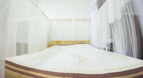 a white bed in a room with a window at Maximize Brand New Hostel Udonthani in Udon Thani