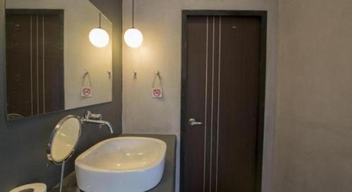 a bathroom with a sink and a mirror at Maximize Brand New Hostel Udonthani in Udon Thani
