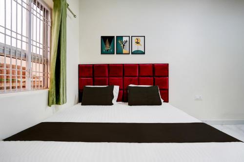 a room with two pillows and a red wall at Super Hotel O Ugat Canal Surat Formerly Royal Orbit in Rānder