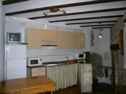 eine Küche mit einem weißen Kühlschrank und einem Tisch in der Unterkunft Casa Yayo in Puebla de Benifasar