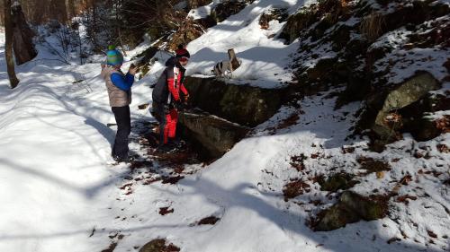 two people standing in the snow next to a dog at Chata - Srub Kašparáci in Janske Lazne