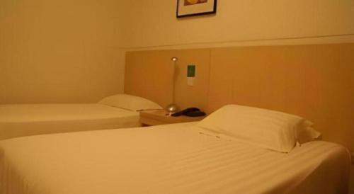 Un ou plusieurs lits dans un hébergement de l'établissement Jinjiang Inn Wenzhou Shuangyu The Terminal
