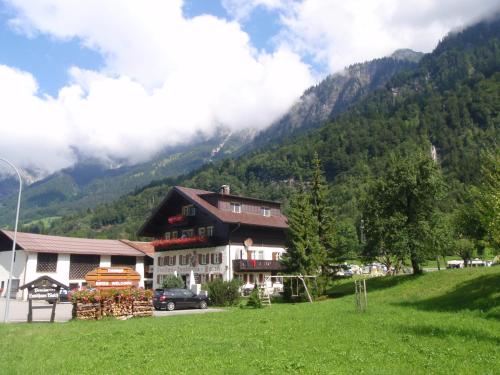 a house on a hill with mountains in the background at Walch's Camping & Landhaus in Braz