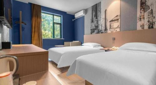 Un ou plusieurs lits dans un hébergement de l'établissement Jinjiang Inn Wenzhou Shuangyu The Terminal