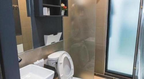 a bathroom with a toilet and a sink and a mirror at The Smart Hostel in Nakhon Ratchasima