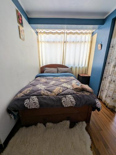 a bedroom with a bed with a blue wall at MONOAMBIENTE Sicuani in Sicuani