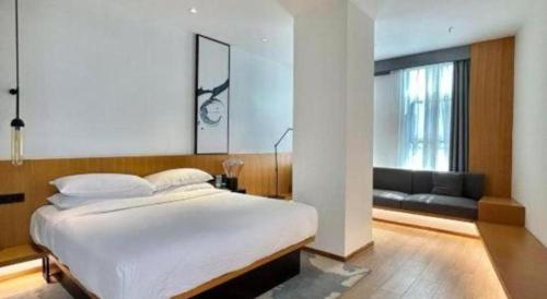 a bedroom with a large white bed and a couch at Fairfield by Marriott Baoding High-Tech Zone in Baoding