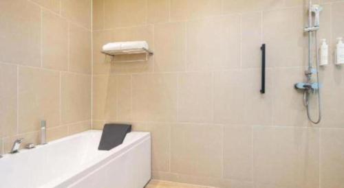 a bathroom with a bath tub with a book on it at Fairfield by Marriott Baoding High-Tech Zone in Baoding