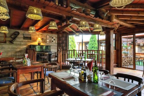 a restaurant with wooden tables and chairs and lights at Grand Częstochowa in Częstochowa