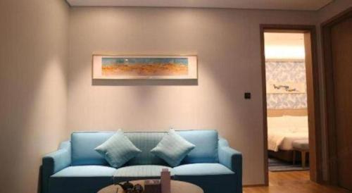 a living room with a blue couch with pillows at Emerald Bay Hotel in Yuxi
