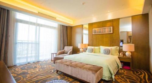 a large hotel room with a bed and a chair at Wuhan Gleetour Hotel in Wuhan