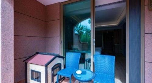 a toy house and blue chairs in a window at Emerald Bay Hotel in Yuxi