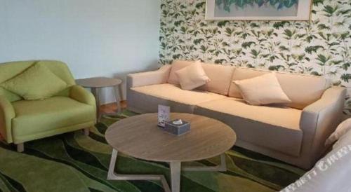 a living room with a couch and a table at Emerald Bay Hotel in Yuxi