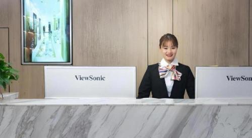 a woman in a suit sitting at a counter with two laptops at GreenTree Inn Express Hebei Shijiazhuang Zhengding County Changshan Dong Road in Shijiazhuang