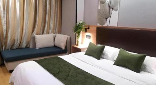 a hotel room with a bed and a couch at GreenTree Inn Yixing Zhangzhu Express Hotel in Xinchating
