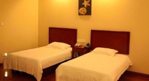a hotel room with two beds and a telephone at GreenTree Inn Yixing Zhangzhu Express Hotel in Xinchating
