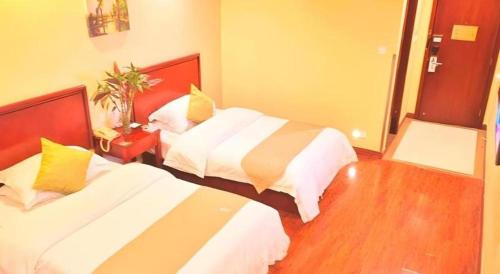a hotel room with two beds in a room at GreenTree Inn Yixing Zhangzhu Express Hotel in Xinchating