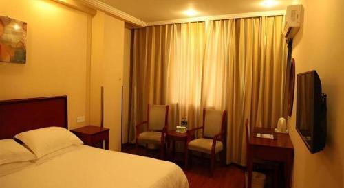 a hotel room with a bed and a television at GreenTree Inn Yixing Zhangzhu Express Hotel in Xinchating
