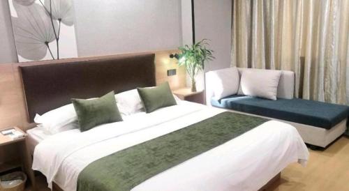 a hotel room with a large bed and a chair at GreenTree Inn Yixing Zhangzhu Express Hotel in Xinchating