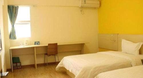 a hotel room with two beds and a desk and a window at 7 Days Inn Chengdu Sichuan University South Railway Station in Chengdu