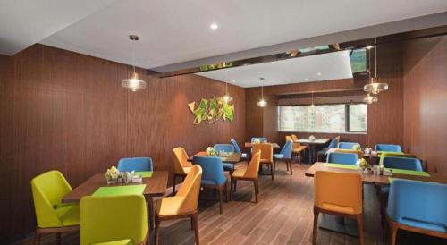 a dining room with tables and chairs in a restaurant at Hampton by Hilton Zhuhai Doumen in Zhuhai
