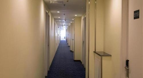 a long hallway with white walls and a long hallway with white halls at 7 Days Inn Xi'an North Economic Development Zone 4th Fengcheng Road in Xi'an