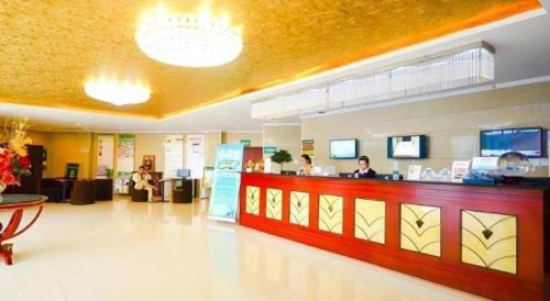 a restaurant with a counter with people sitting at it at GreenTree Inn Jiangsu Xuzhou Jinshan Bridge Building Jinqiao Road Express Hotel in Xuzhou