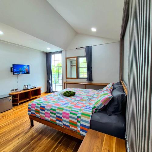 a bedroom with a bed and a television in it at One Sa-Kaeo Homestay in Ban Non Chan