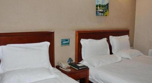 a hotel room with two beds and a phone at GreenTree Inn Shanghai Hongqiao Airport Huqingping Highway Shell Hotel in Shanghai