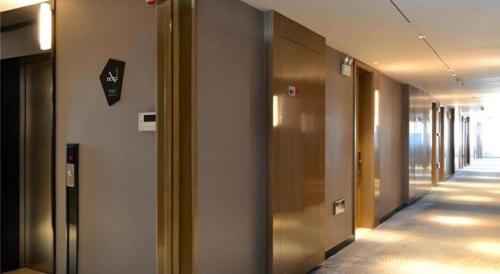 a hallway with elevators in a building with a hallwayngth at Echarm Hotel Jinan Railway Station Daming Lake in Jinan